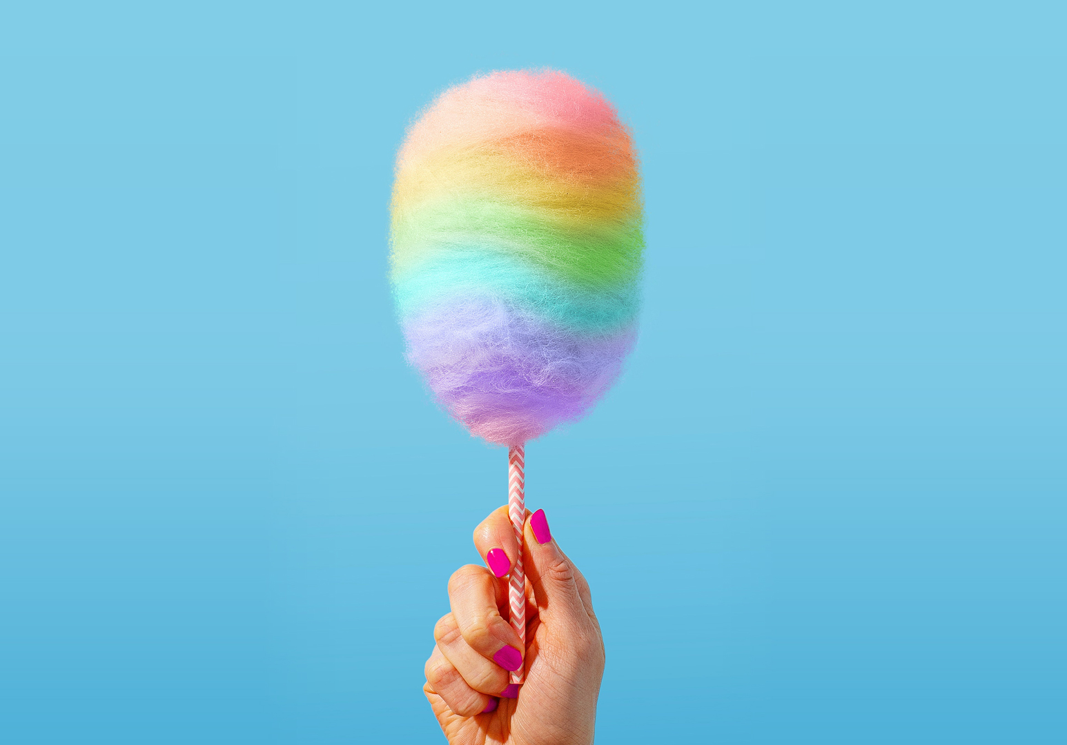 woman holding rainbow cotton candy