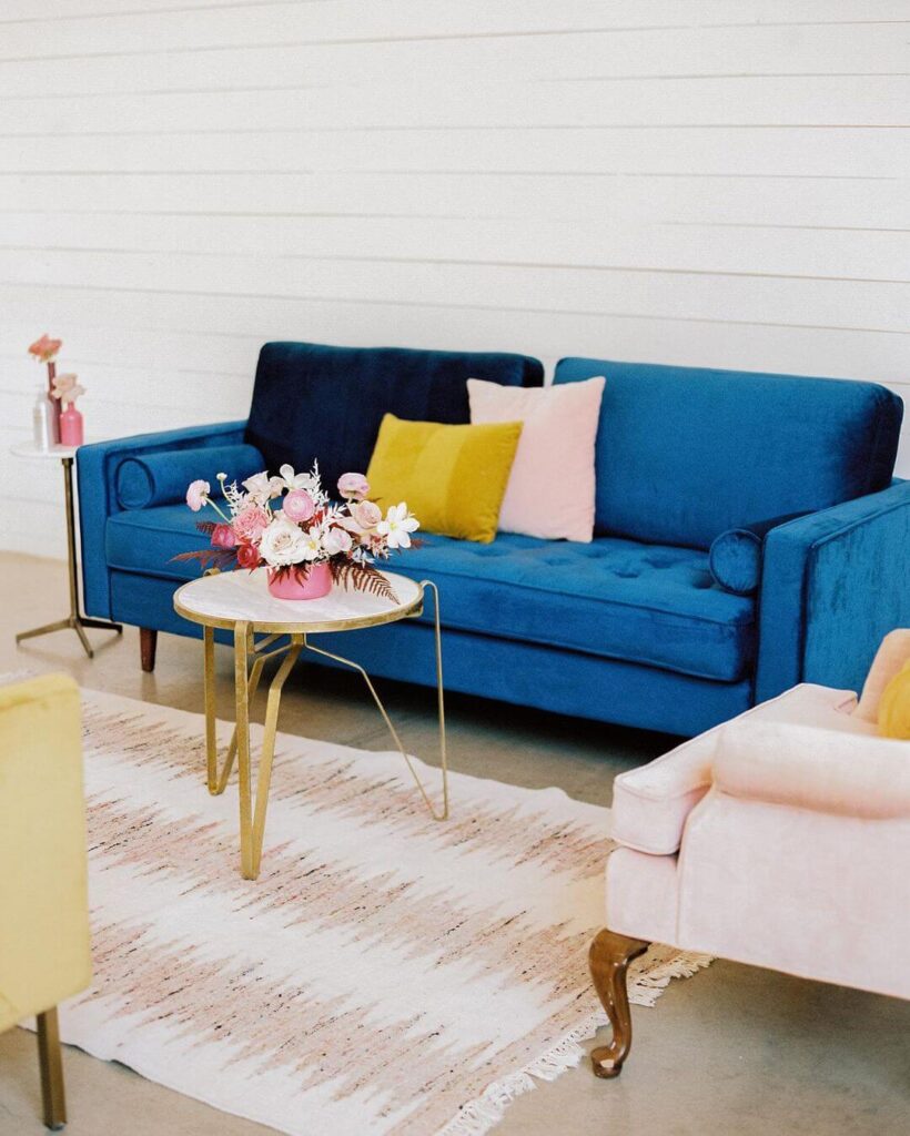 Furniture rentals including blue couch, pink chair, and gold side table